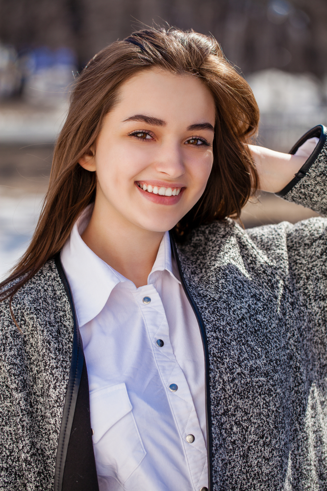 Young woman smiling confidently after treatment with an oral surgeon in Frederick, MD