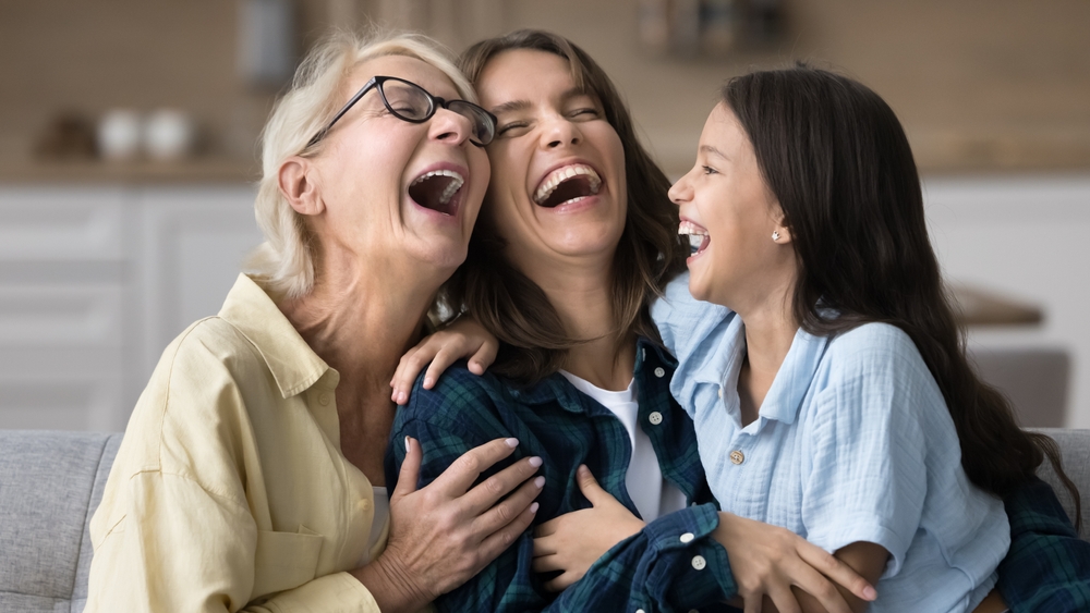 Multi-generational family smiling together after oral surgery care in Frederick, MD